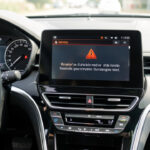 Injection à contrôler vs voyant moteur : quelle différence avant de rouler ? Tableau de bord moderne de voiture avec un message d’alerte générique à vérifier, éclairage de conduite de jour, ambiance réaliste et détails nets du tableau.